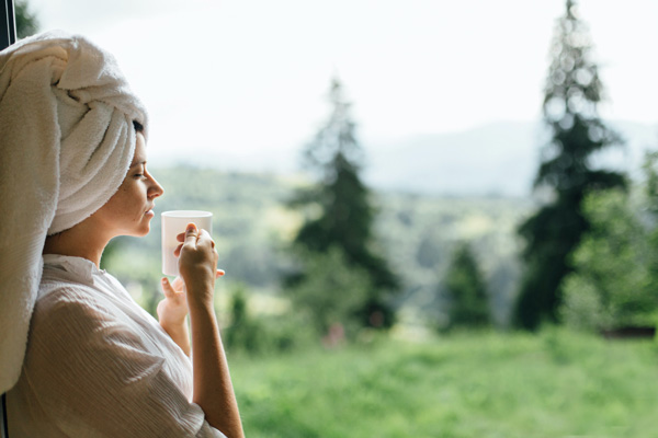 Woman with morning coffee outdoors after shower.