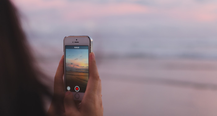 Brainwave secrets of YouTube creators. YouTuber on beach with iPhone. Brainwave secrets of YouTube creators. YouTuber on beach with iPhone.