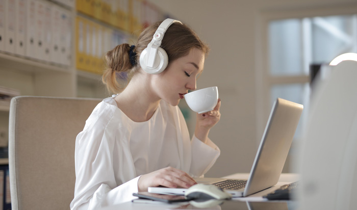 Woman writer with headphones creating profits from Audible audiobook reviews. Woman writer with headphones creating profits from Audible audiobook reviews.