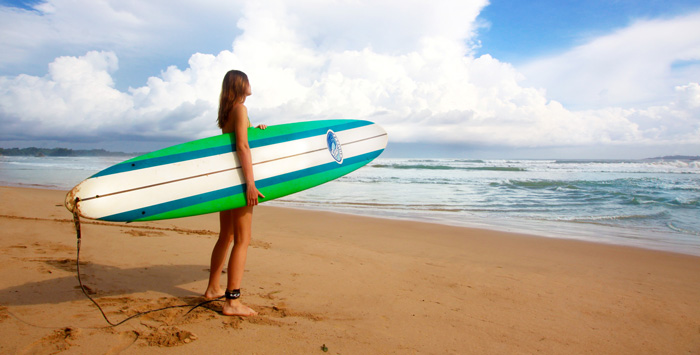 Confident female surfer on beach. Amazon Audible program helped her greatly.