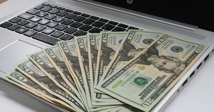 Twenty dollar bills on laptop Twenty dollar bills on laptop
