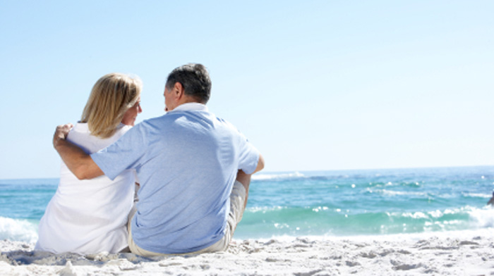 Older couple sitting on beach hugging. Spirituality and relationships. Older couple sitting on beach hugging. Spirituality and relationships.