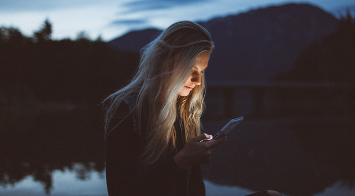 Woman focus on iPhone at night.