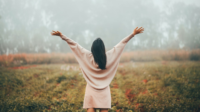 Woman happy. Arms upraised. Outdoors.