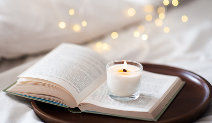 Women writers and scented candles. Book and bed. Women writers and scented candles. Book and bed.