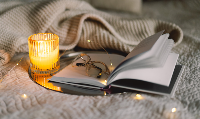 Scented candles and women writers. Throw blanket and book. Scented candles and women writers. Throw blanket and book.