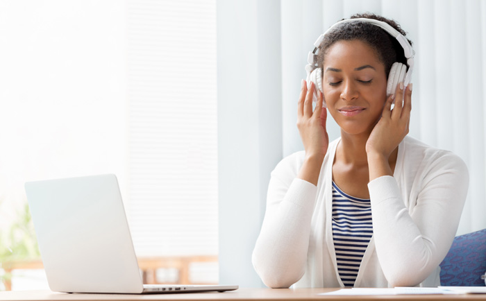 African-American woman writer listening to binaural beats. African-American woman writer listening to binaural beats.