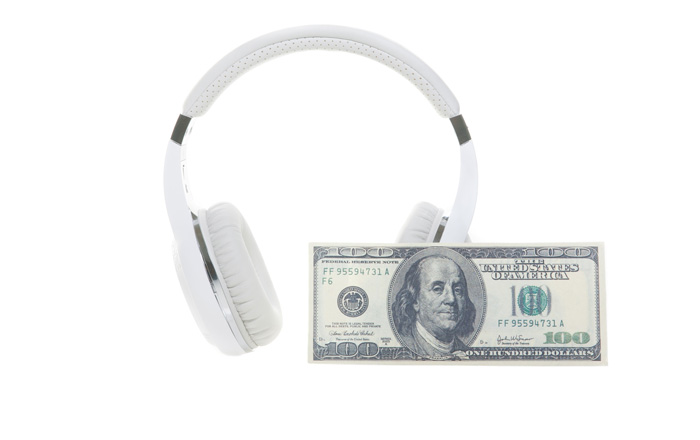 White headphones and a 100 dollar bill. White headphones and a 100 dollar bill.