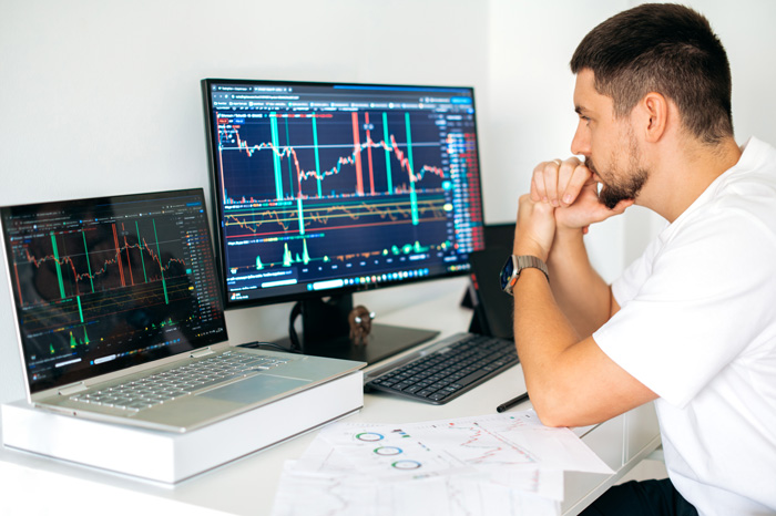 Man with large screen and laptop to gain crypto profits. Man with large screen and laptop to gain crypto profits.