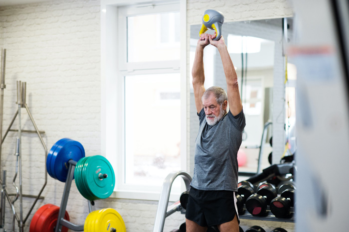 Senior man swing kettlebell to build muscle. Senior man swing kettlebell to build muscle.
