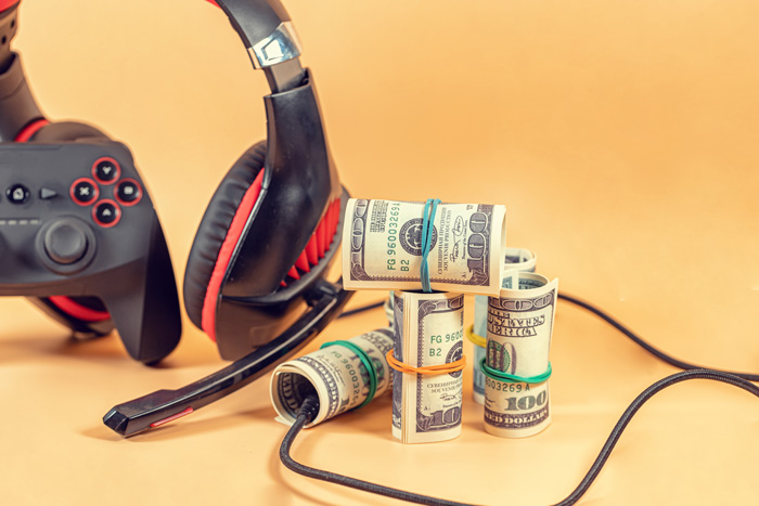 Black headphones and 100 dollar bills. Tan background. Black headphones and 100 dollar bills. Tan background.