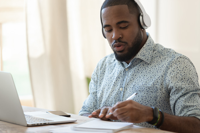 African-American writer listening to binaural beats. African-American writer listening to binaural beats.