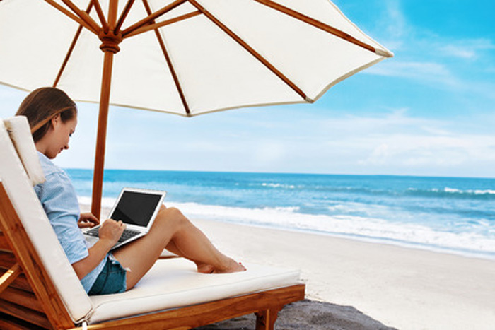 Woman beach umbrella with laptop. Woman beach umbrella with laptop.