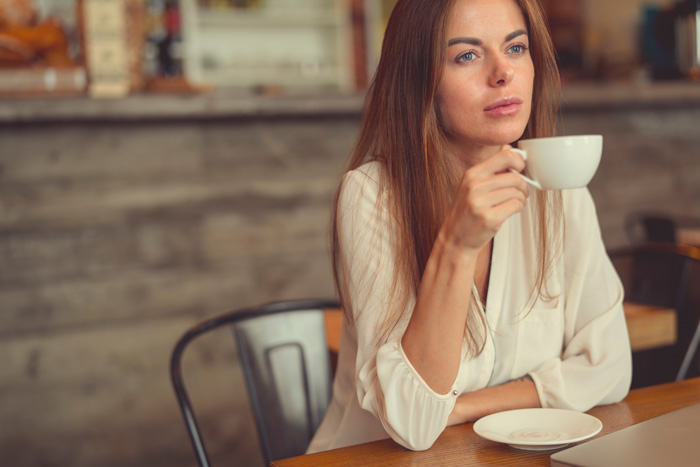 Thoughtful woman in cafe thinking about her life script. Thoughtful woman in cafe thinking about her life script.