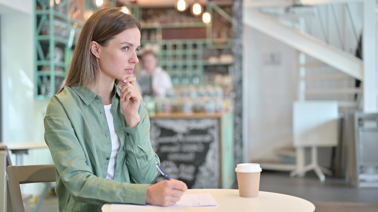 Young woman in coffee shop thinking through a decision to change her life. Young woman in coffee shop thinking through a decision to change her life.
