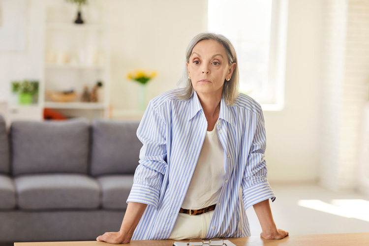 Mature woman accepting hard news in her living room.