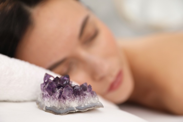 Woman sleeping with a healing crystal stone.