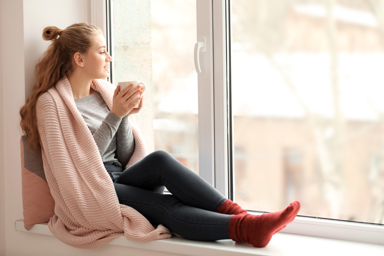 Young woman with throw blanket to relieve stress and experience a zen vibe. Young woman with throw blanket to relieve stress and experience a zen vibe.