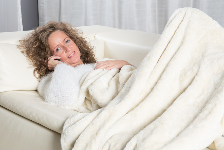 Woman on her couch reieving stress with a soft throw blanket. Woman on her couch reieving stress with a soft throw blanket.