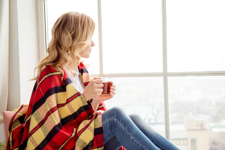 Woman using a throw blanket for stress releif and relaxation. Woman using a throw blanket for stress releif and relaxation.